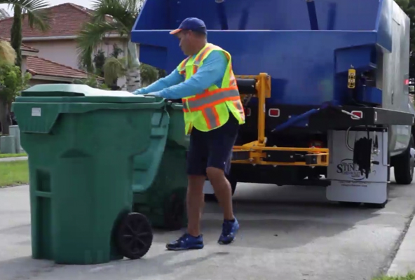 Trash Cans are loaded onto our vehicle to be cleaned.